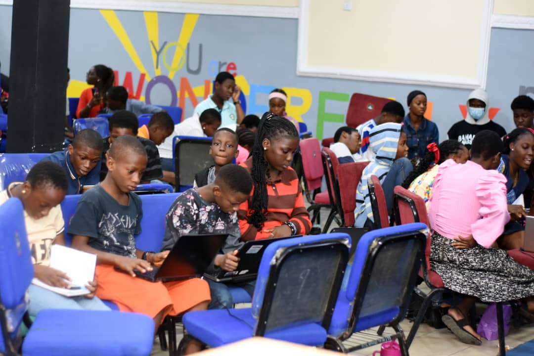 Young JENECONK learners using laptops and notes during a practical bootcamp